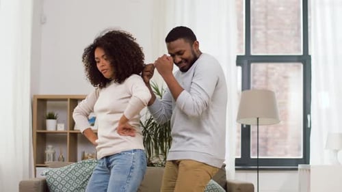 Happy Couple Dancing Together in Living Room