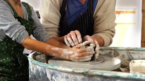 Girl and Woman Working with Clay on Pottery Wheel