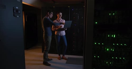 Man and Woman with Laptop in Data Center
