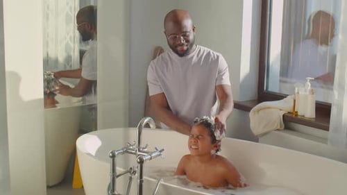 Father Washing Child's Hair in Bubbly Bathtub