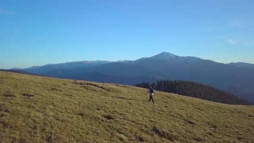 Lone Hiker Walks on Mountain on Clear Day