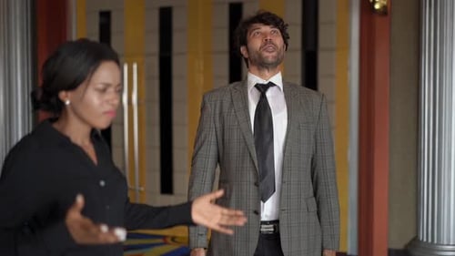 Businesswoman Arguing with Man in Suit Indoors