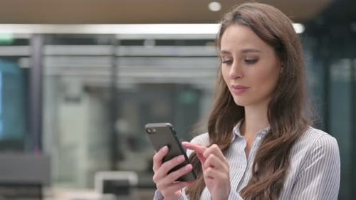 Young Woman Using Phone in Office Setting