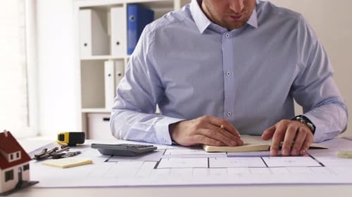 Male Architect Counting on Calculator at Office