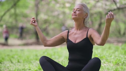 Mature Woman Meditating in a Spring Meadow