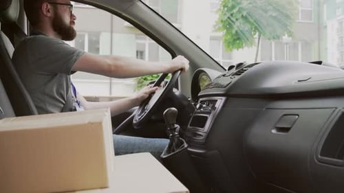 Bearded Man Driving Car with Boxes