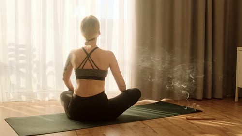 Woman Meditating in Yoga Pose with Incense