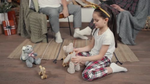 Girl Playing with Toys at Christmas with Family