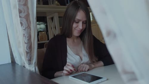 Woman Uses Tablet in Cafe