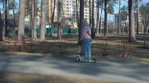 Femme chevauchant une trottinette dans le parc
