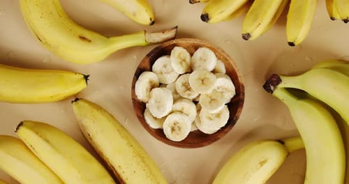 Banana Slices in Bowl With Fresh Yellow Bananas