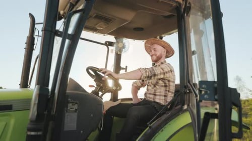 Farmer Smiling in Green Tractor on Sunny Day