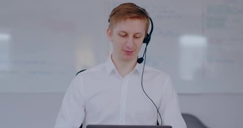 Young Adult Man Wearing Headset at a Workplace