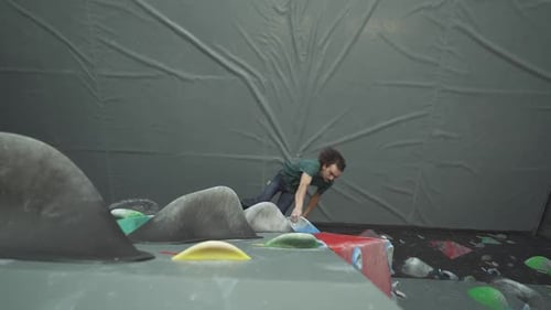 Man Bouldering on Artificial Rock Climbing Wall
