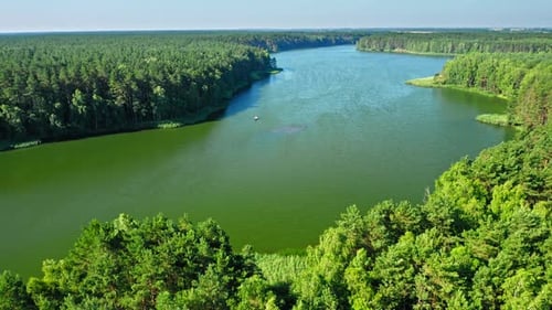 Small fishing boat on lake among forest in Poland