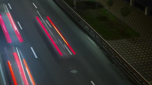 Scheinwerfer vorbeifahrender Autos bei Nacht, Zeitraffer