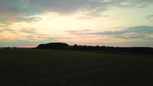 Aerial view of dark yellow sunset over farm fields in spring.