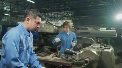 Two professional workers team working in the metalwork manufacturing factory.