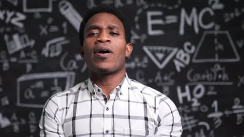 Young Adult Man with Mask in Front of Chalkboard