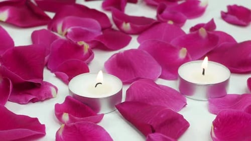 Romantische Rosenblätter und Kerzen