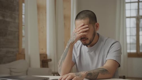 Man Uses Smartphone at Table Indoors