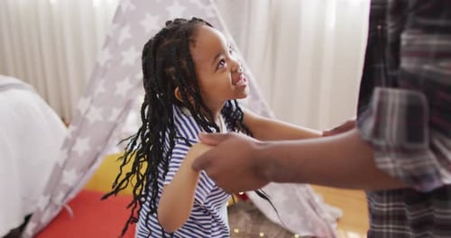 Child Dancing with Adult Holding Hands at Home