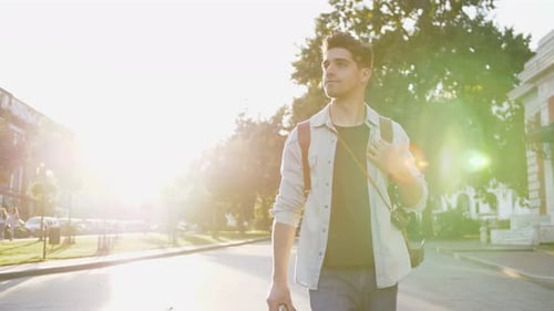 Attractive Young Handsome Man Tourist with Backpack Walking in City Center and Looking Around During