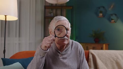 Senior Man Using Magnifying Glass to Look Closely