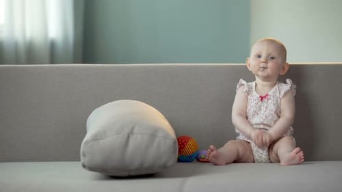 Aktives Baby klatscht in die Hände und lacht, glückliches Kind hat Spaß, Kindheit