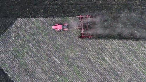 Red Tractor Plows the Ground. View From the Drone.
