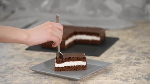 Hand Cuts Into Chocolate Cake Slice With Fork