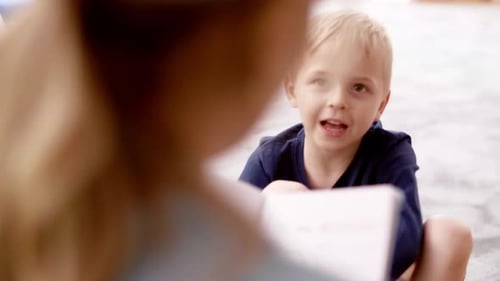 Kleiner Junge im Gespräch mit dem Lehrer in der Vorschule