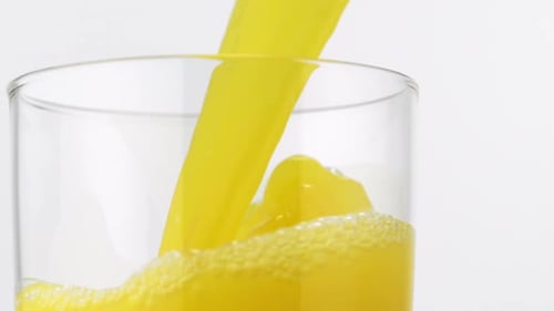 Yellow Liquid Being Poured in Glass Close Up