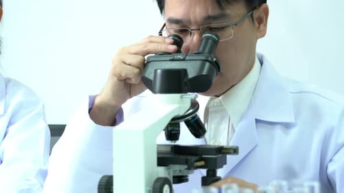 Scientist male looking microscope