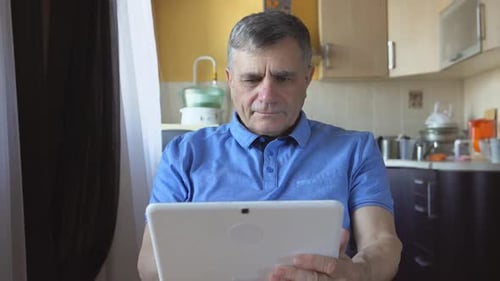 Man Using Tablet in Kitchen Interior