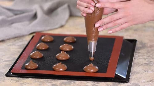 Preparing Chocolate Batter onto Baking Sheet with Piping Bag