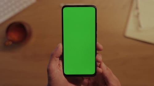 Close Up of Male Hands Holding Cell Phone with Green Screen