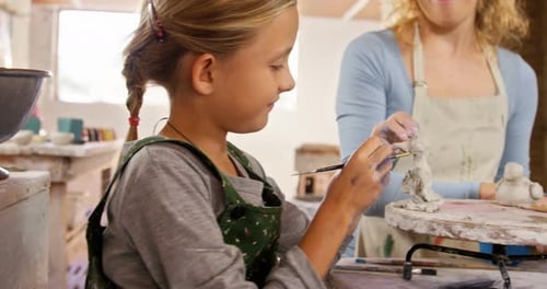 Child and Woman Sculpting Clay Together Indoors