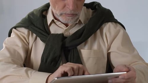 Senior Man Using Tablet Indoors