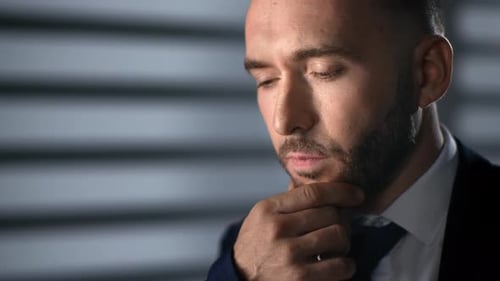 Man in Suit Contemplating Indoors