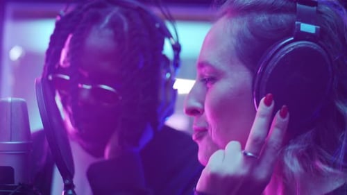 Une femme caucasienne et un homme noir enregistrent une chanson ensemble