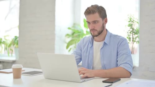 Young Creative Man Working on Laptop in Modern Office