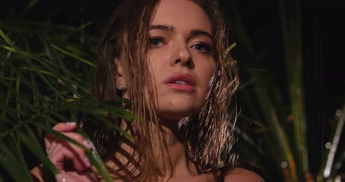 A Young Girl Enchants the Eye Holding a Branch of a Plant