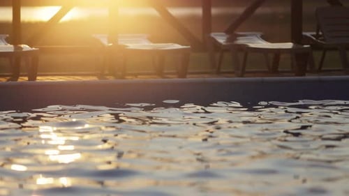 Top View of Swimming Pool with Clear Water on Vacation on Sunset Background