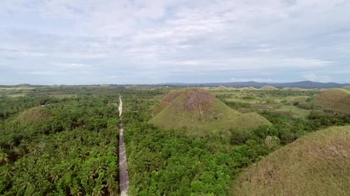 Route avec vue aérienne traversant le complexe de Chocolate Hills, Batuan, Philippines.