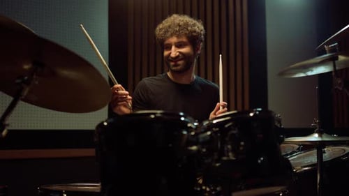 Cheerful Musician Playing on Drum Kit Indoor. Joyful Artist Having Fun in Hall.