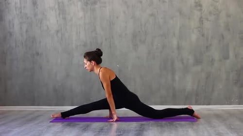 Flexible Woman Practicing Yoga Split Indoors on Mat