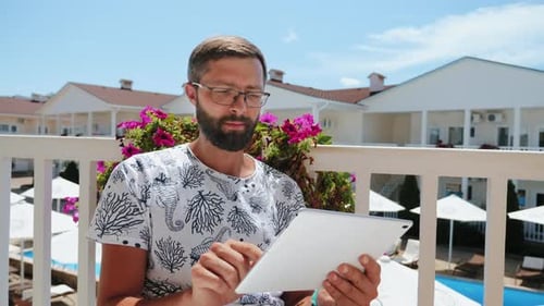 Man with Beard and Glasses Uses Tablet PC