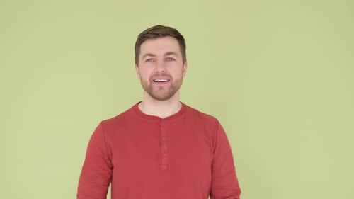 Smiling Man with Beautiful White Teeth and Stylish Hairstyle on Olive Background in Studio