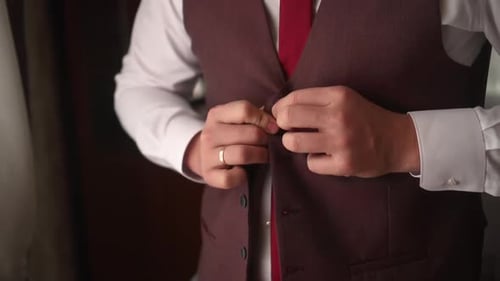 Man Buttoning Vest Before Wedding Celebration